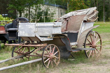 Fototapeta na wymiar Old carriage in a rural courtyard on a summer day