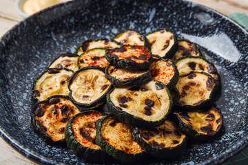 Plate with tasty grilled zucchini on table, closeup