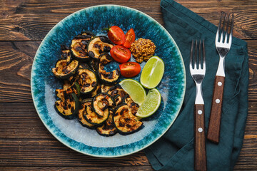 Plate with tasty grilled zucchini on wooden background