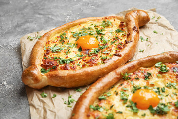 Tasty Ajarian khachapuri on grunge background, closeup