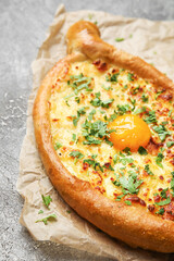 Tasty Ajarian khachapuri on grunge background, closeup