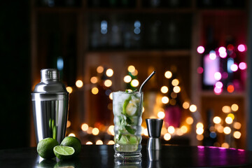 Glass of tasty mojito on table in bar