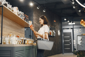Beautiful woman in the store buys groceries.