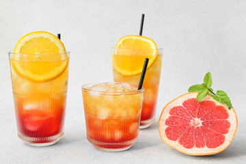 Glasses of tasty Tequila Sunrise cocktail on light background