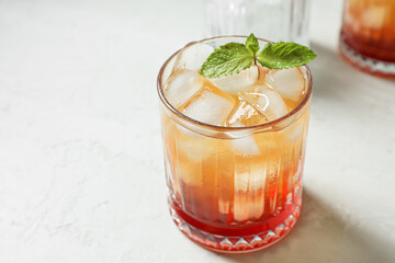 Glass of tasty Tequila Sunrise cocktail on light background