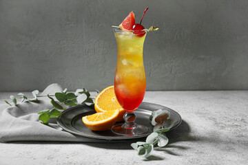 Glass of tasty Tequila Sunrise cocktail on table