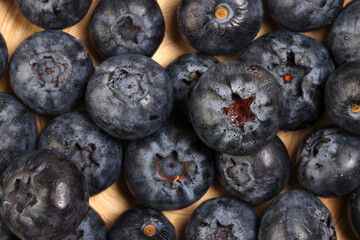 Fresh ripe deep purple Blueberry on old wooden plate macro closeup top view