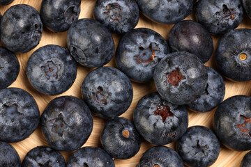 Fresh ripe deep purple Blueberry on old wooden plate macro closeup top view