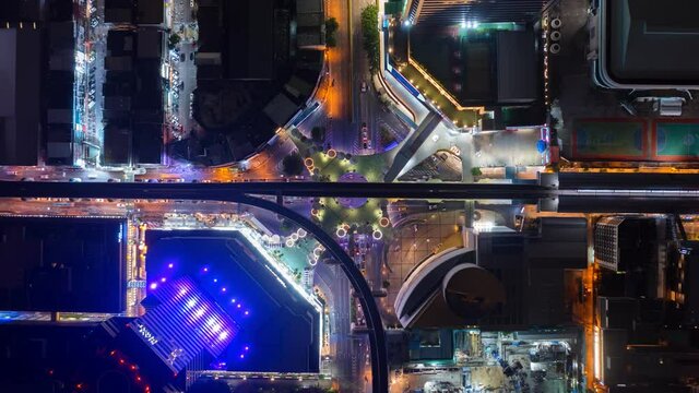 Time lapse of aerial view of Siam Bangkok Art and Skywalk aerial view in MBK Culture Center intersection or junction with cars traffic skyscraper buildings. Bangkok City in downtown at night, Thailand