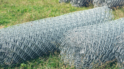 Rolls of wire mesh steel for construction put a pile on the ground. Closeup of Metal Steel...