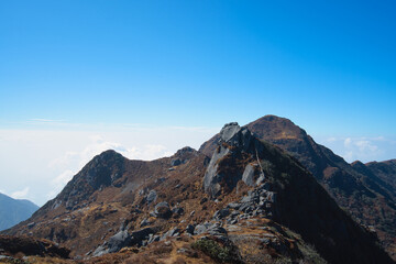 The natural scenery of the tawny mountains under the blue sky and white clouds. View of the mountains along the way. Travel to the Tsomgo Lake (Changu Lake), in the Indian state of Sikkim.