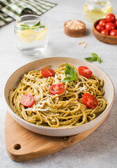 Spaghetti pasta with pesto sauce and cherry tomatoes on a plate. Menu, Italian cuisine.
