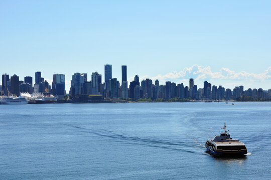 Scenic view of downtown Vancouver, with a Seabus commuter passenger ferry on the Burrard Inlet in the foreground, as seen from North Vancouver.