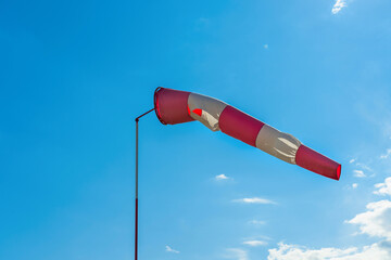 Wind indicator on the airfield against the blue sky