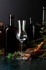 Obraz premium Gin with juniper seeds and branches on an old table.