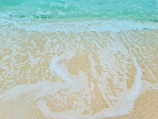 Fototapeta na wymiar Soft blue waves on a clean sandy beach. travel photos
