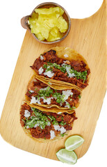 Tacos al pastor, tradicional comida mexicana, con cebolla, cilantro, piña, salsa roja o guacamole.