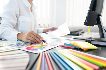 interior designer or creative graphic designer working on project architectural with colour samples with work tools and equipment for selection in office