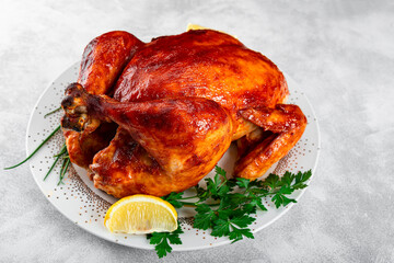  Whole baked chicken in sauce with paprika on a plate and a Christmas table setting top view