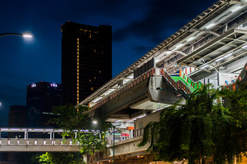 Night view of a train station with tall buildings in the background.