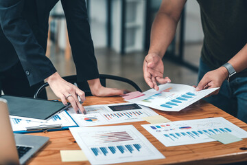 Close-up of a group of business people brainstorming analyzing working statistics graphs documents...