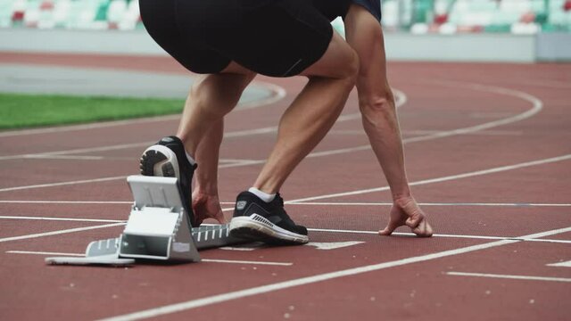 Stadium, man sprinter is preparing for the start of a training run in short-distance, professional track runner.