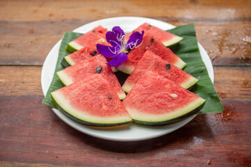 sliced watermelon on wooden table outdoors