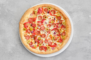 Top view of small size pizza with thin sausage, bell pepper, olives