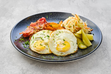 Fried eggs with bacon and pickled cabbage with cucumber