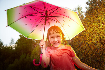 Young funny girl with umbrella under rain in summer day