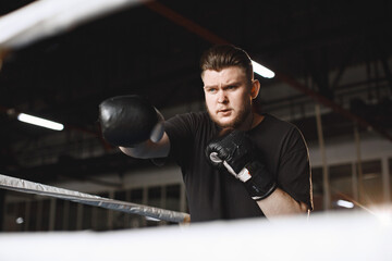 Man in a black t-shirtg boxing in a gym