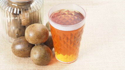 Monk fruit or Luo Han Guo. Dried fruits for healthy sweetener drink. Natural herbal remedy and glass bottle background. Monk fruit drink for who concern health and sugar substitute. 