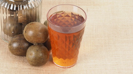 Monk fruit or Luo Han Guo. Dried fruits for healthy sweetener drink. Natural herbal remedy and glass bottle background. Monk fruit drink for who concern health and sugar substitute. 