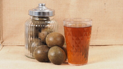 Monk fruit or Luo Han Guo. Dried fruits for healthy sweetener drink. Natural herbal remedy and glass bottle background. Monk fruit drink for who concern health and sugar substitute. 