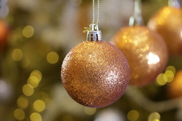 Arrange golden glitter Christmas ornaments.