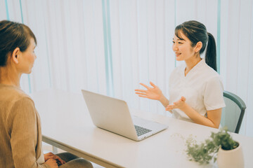 カウンセリングする白衣を着た女性（パソコン）
