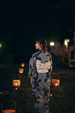 神社の参道を歩く浴衣の女性