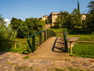 wooden and metal bridge leading to a village