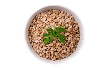 Boiled buckwheat in a plate with parsley leaf and butter on a white