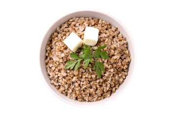 Boiled buckwheat in a plate with parsley leaf and butter on a white