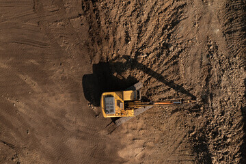 Overhead view of excavator doing earth works on a rocky surface
