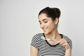 cheerful woman in a striped t-shirt toothbrush in hand isolated background