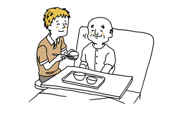 おじいさんの食事の介助をしている介護士の男性