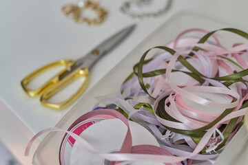 Set of ribbon, tailor's scissors on a white wooden table. Tailoring concept. Accessories for sewing and needlework.