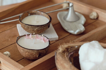 Coconut Spa concept: coconut, coconut oil and candle with the scent of coconut on a wooden table. aromatherapy concept