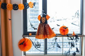 Home decor for Halloween celebration with paper garland orange color, bat on window