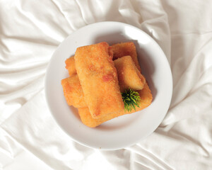Fried spring rolls isolated on a bright background. This typical Semarang food, sometimes spelled lun pia, is a kind of traditional Chinese-Javanese snacks. Blurred focus. Snack food mockup