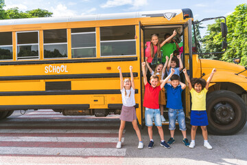 Group of young students attending primary school on a yellow school bus
