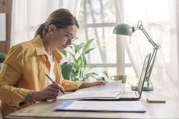 Young businesswoman sitting at desk and working from home