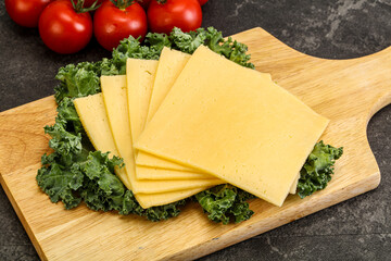 Sliced Gauda cheese over board